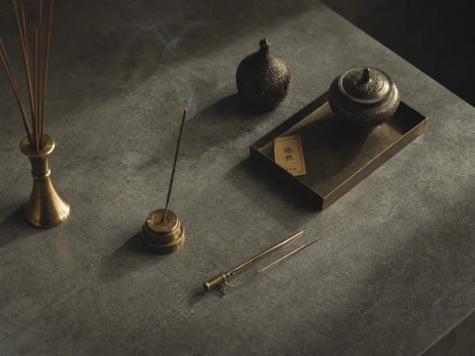 A close-up ritual shot of lighting natural Chinese incense with a match in a light-filled modern interior.
