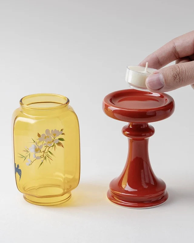 Yellow glass jar with floral design and red candle holder show chinese aesthetics