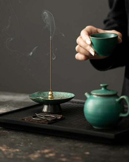 Burning incense on a blue-green ceramic incense stick holder with reactive glaze finish, perfect for Chinese incense ritual and meditation spaces