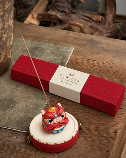 Red Guardian Lion incense holder on a drum-inspired base beside a box of Chinese incense