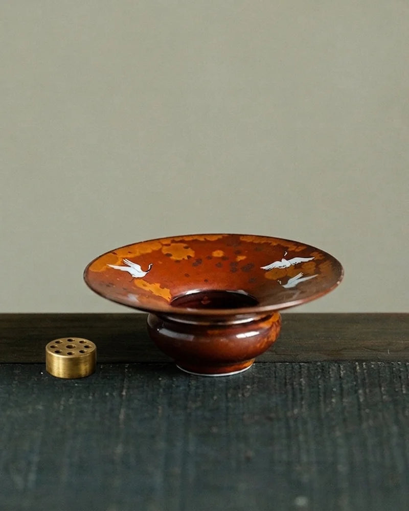 Detail image of Chinese ceramic incense holder with painted flying cranes and nine-hole insert, handcrafted incense stick holder with artistic design